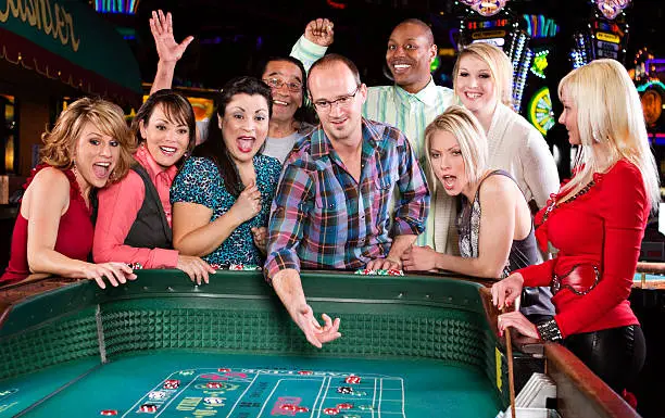 Large group of happy excited people playing craps in a casino. Click photo below to view similar gambling images.