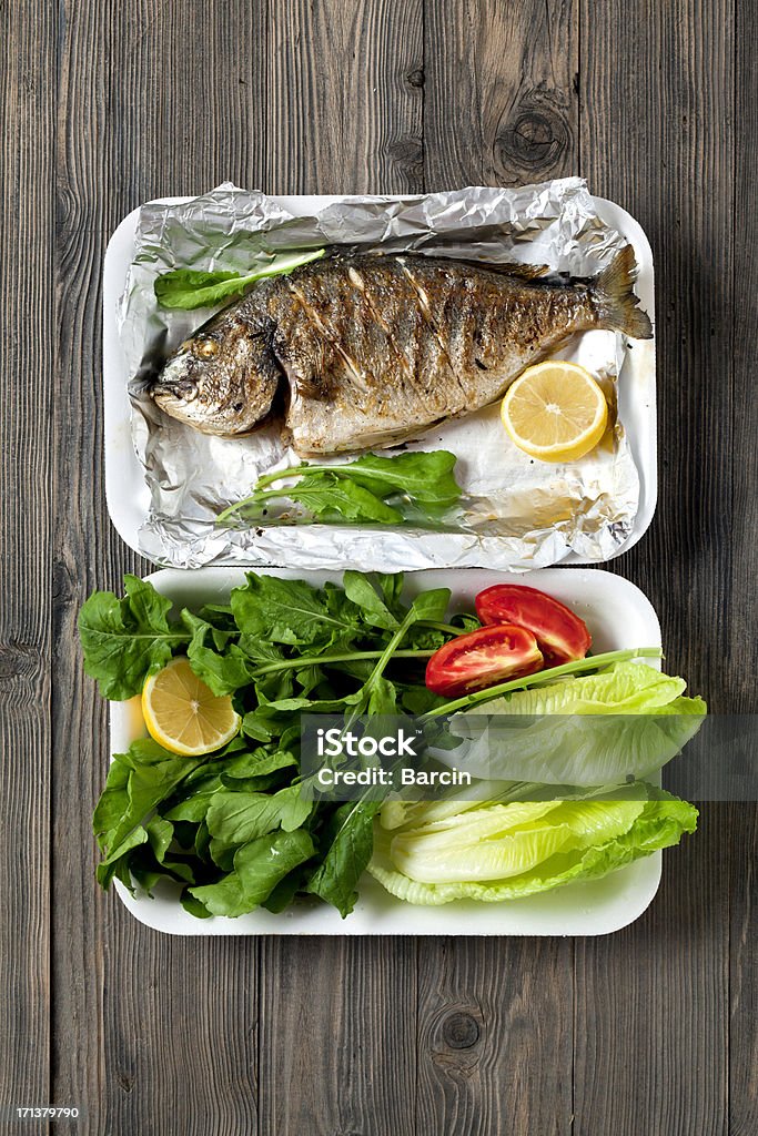 Grilled sea bream Grilled sea bream in foil with salad on a picnic table High Angle View Stock Photo