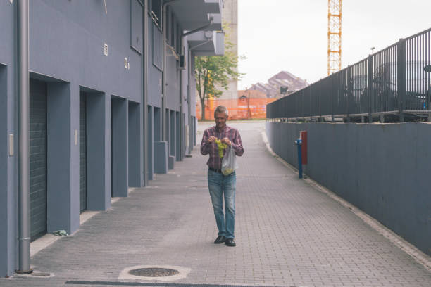 Man in the city, eating ripe autumn grapes outdoors