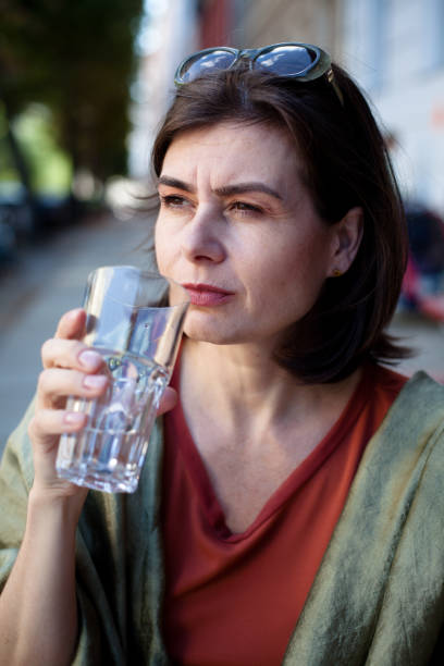 istock beautiful mature woman in a cafe drinks water 171380309