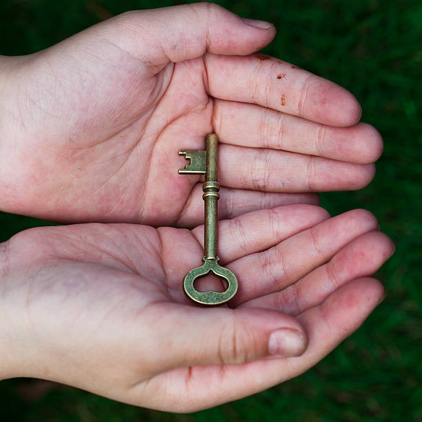 main tenant la clé de la réussite - human hand key giving carrying photos et images de collection