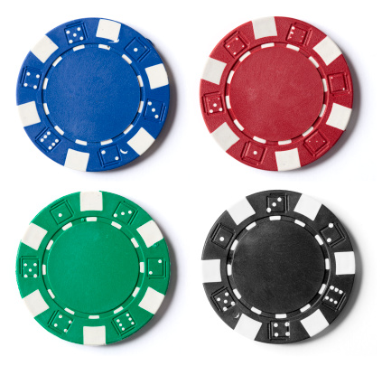 A picture of four different color poker chips on a white background.