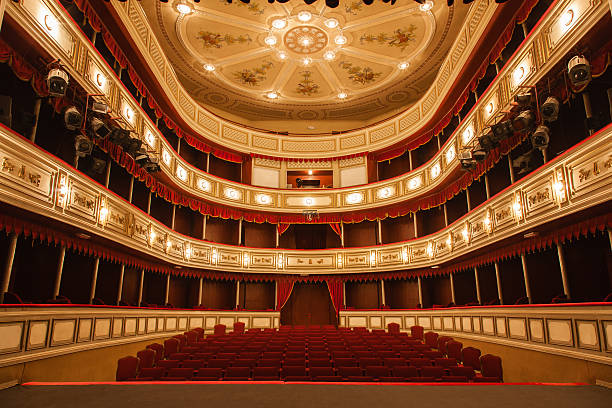 Classical Theater Classical Theater with Red stage curtain with arch lights and shadows.View from the stage opera photos stock pictures, royalty-free photos & images