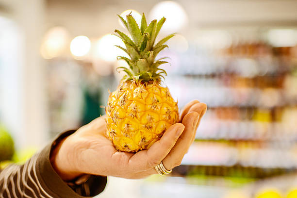 istock Man choosing mini pineapple in grocery store 171381534