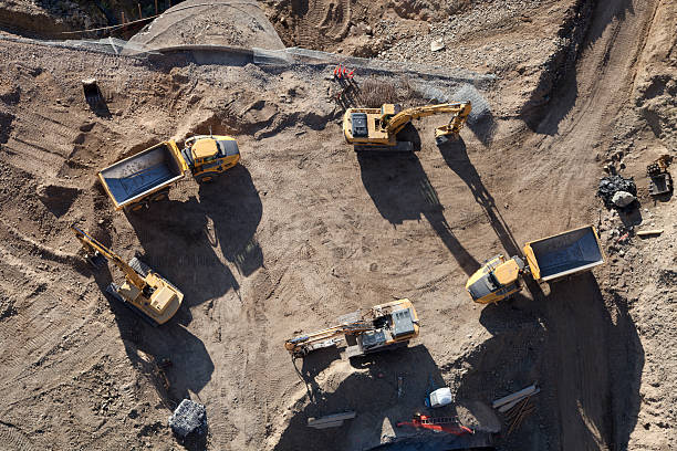 Constructing Shadows Heavy construction equipment as seen from on high and with a low angle of sunlight. construction vehicle stock pictures, royalty-free photos & images