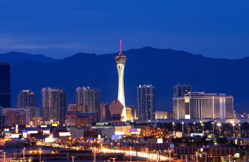 Colorful shot of Las Vegas showing the familiar needle with mountains in the background.