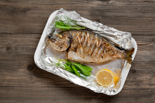 Grilled sea bream in foil on a picnic table