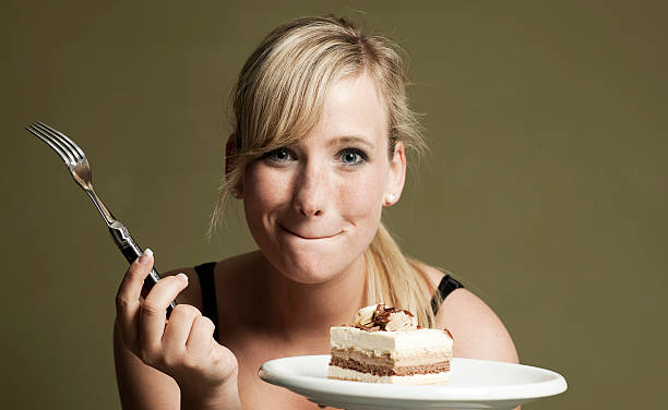 Blond woman eating cake stock photo