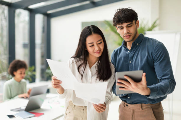 istock Diverse Business Colleagues Using Digital Tablet Holding Papers In Office 1713824694