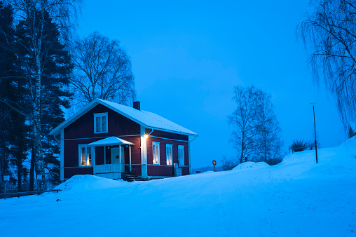 Typical wooden house in Sweden during winter by night.
