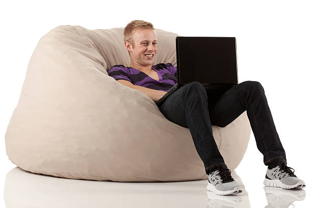 istock Man reclining on bean bag and using a laptop 171383031