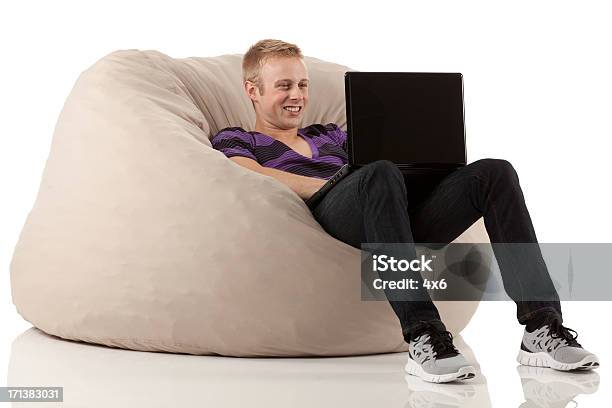 Man Reclining On Bean Bag And Using A Laptop Stock Photo - Download Image Now - Bean Bag, Cut Out, People
