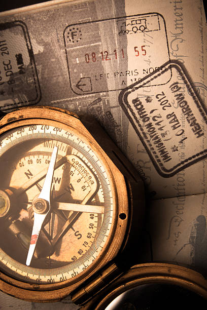 Antique Compass and Well-Traveled Passport An antique brass compass laying on top of a United States passport book with stamps from European airports and train stations traveled stock pictures, royalty-free photos & images