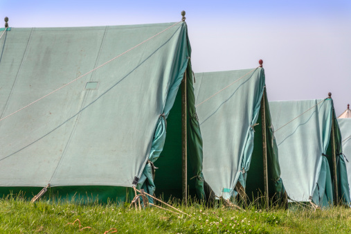 a row of canvas tents on a campsite