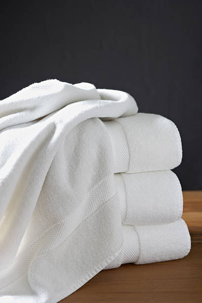 Stack of white towels in a hotel room Stack of decorative white bath towels in a hotel room. Vertical composition. vibrant color lifestyles vertical close up stock pictures, royalty-free photos & images