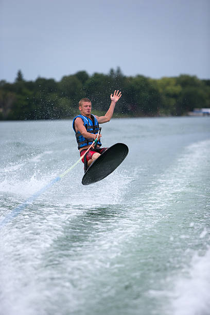 jovem macho joelho snowboard no minnesota lago. - waterskiing motorboating skiing water imagens e fotografias de stock
