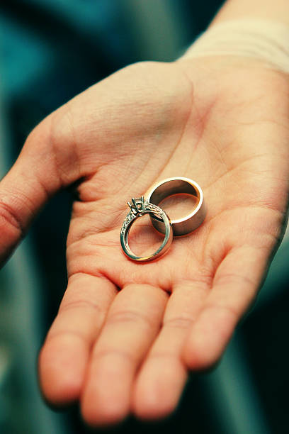 istock Human Hand Holding Two Beautiful Elegant Wedding Rings In Palm 171384557