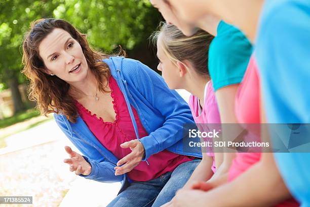 Mujer La Mentoría Grupo De Chicas Preteen Estacionamiento Al Aire Libre Foto de stock y más banco de imágenes de 12-13 años