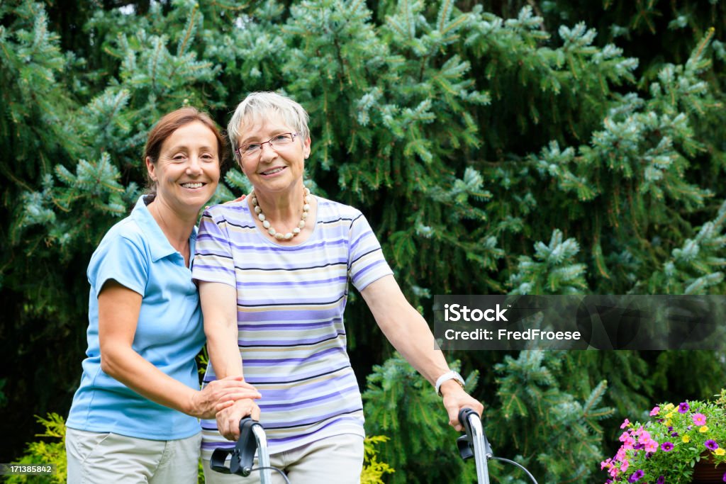 Senior woman with walker and caregiver A Helping Hand Stock Photo