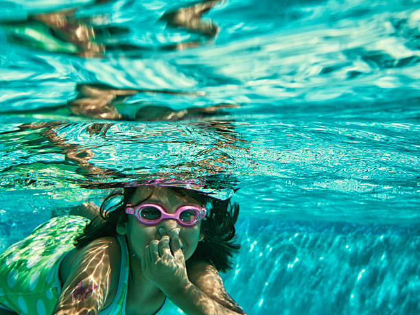 istock young girl swimming underwater 171385890
