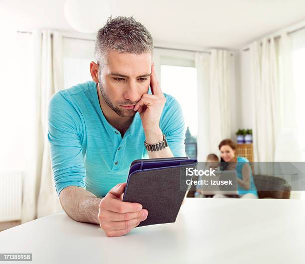 Adult Man Reading Book On Ereader Stock Photo - Download Image Now - Laptop, Two Parents, 30-34 Years