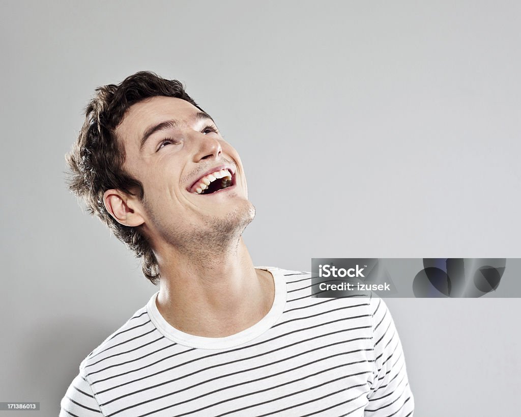 Excited man Portrait of happy young man looking up. Studio shot, grey background. Men Stock Photo