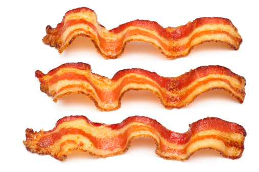 Wavy slices of freshly cooked bacon