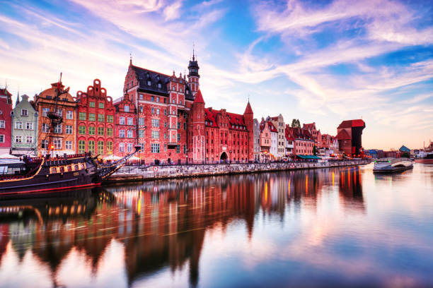 Vieille ville illuminée de Gdansk avec la rivière calme Motlawa au coucher du soleil, Pologne - Photo