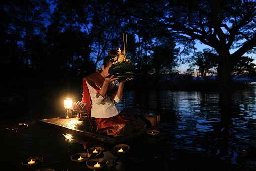 On Loi Krathong day in Thailand, women dressed in traditional Thai attire hold kratongs and float them in the water to pay respect to the Water Goddess during the annual Loi Krathong Traditional Festival held in November.