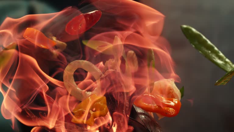 Cooking fried vegetables on fire. Professional chef preparing food