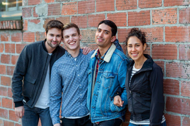 istock Multiracial group of four pose for picture against brick wall 1713965096