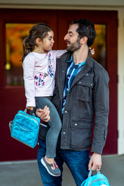 istock Loving father holds young daughter before school 1714010467