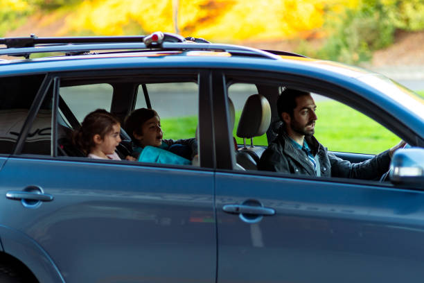 istock Father drives his young children to school 1714010642