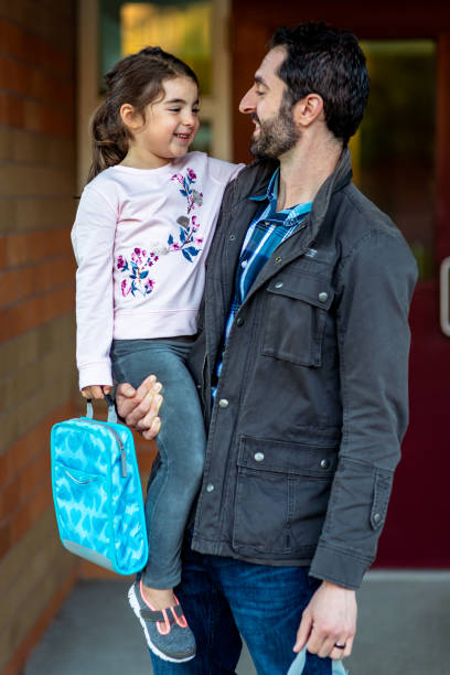 istock Loving father holds young daughter before school 1714010998