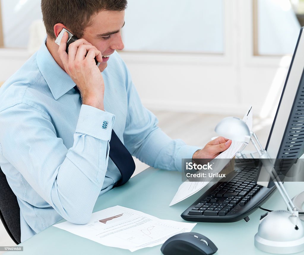 Jeune homme d'affaires à l'aide de téléphone portable au bureau - Photo de Adulte libre de droits