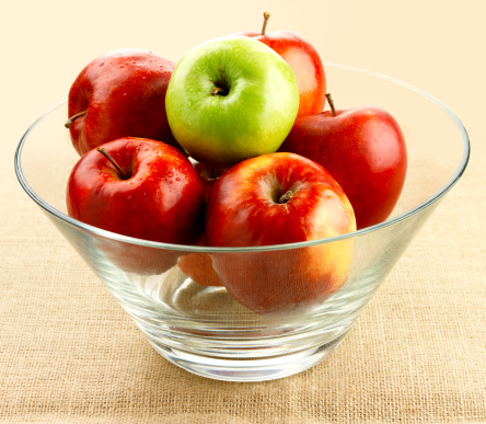 Red apples in a marble plate on white wood background fresh and wet with dew drops in harvest