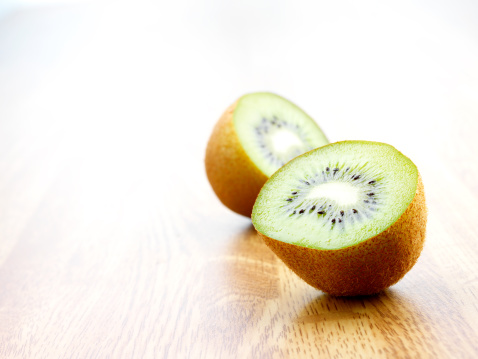 sliced green ripe kiwi, sliced green kiwi fruit on a wooden board