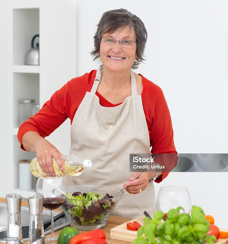 Donna matura preparazione cibi in cucina - Foto stock royalty-free di Adulto