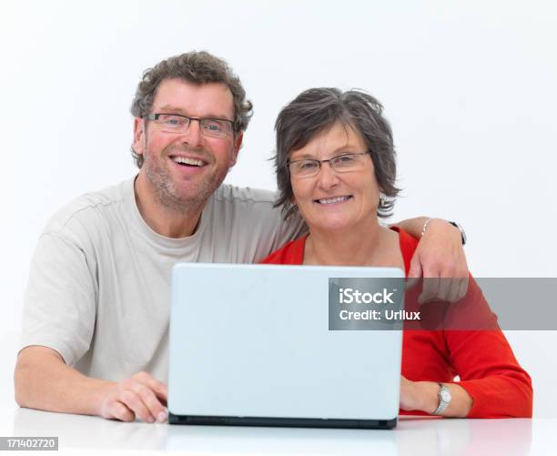 Photo libre de droit de Heureux Couple Dâge Mûr À Laide Dordinateur Portable Sur Fond Blanc banque d'images et plus d'images libres de droit de Adulte