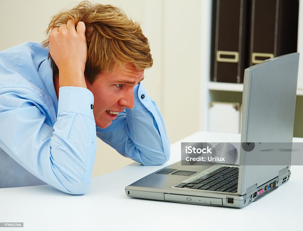 Portrait de jeune homme frustré à la recherche à un ordinateur portable - Photo de Adulte libre de droits