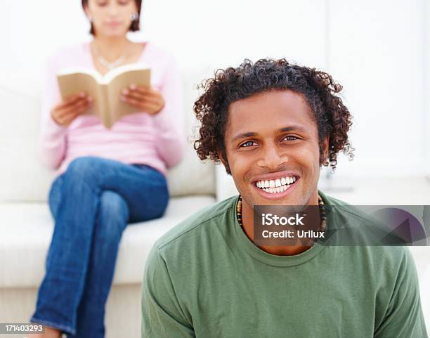 Photo libre de droit de Jeune Homme Souriant Et Femme Lisant Un Livre Dans La banque d'images et plus d'images libres de droit de Adulte