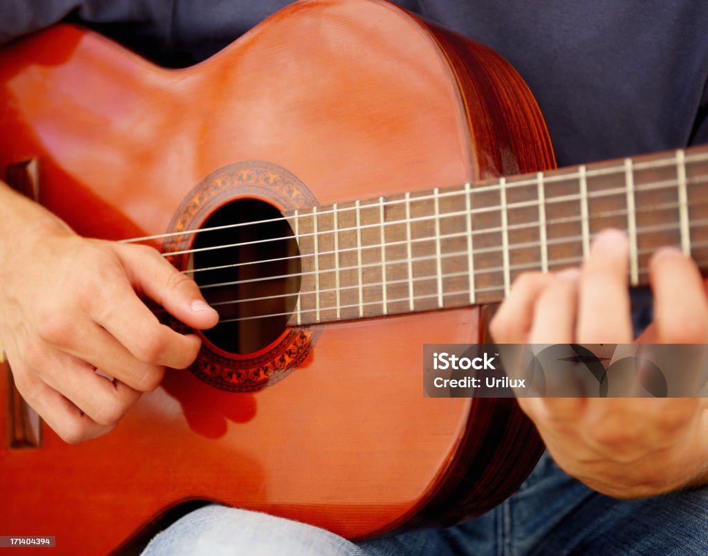 Détail des mains d'un petit garçon jouant de la guitare - Photo de Adulte libre de droits