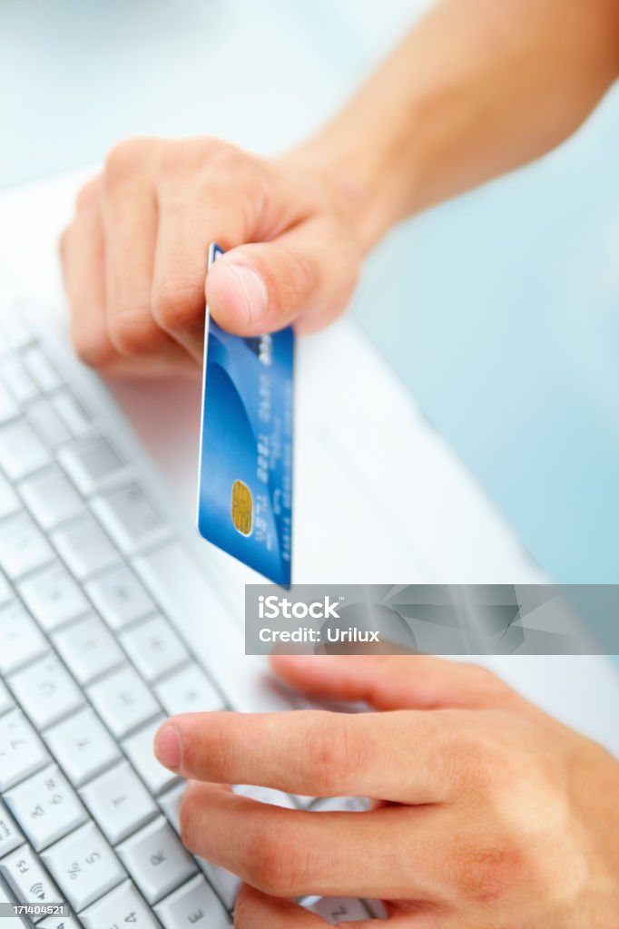 Mão segurando o cartão de crédito em um teclado de computador portátil - Royalty-free Adulto Foto de stock