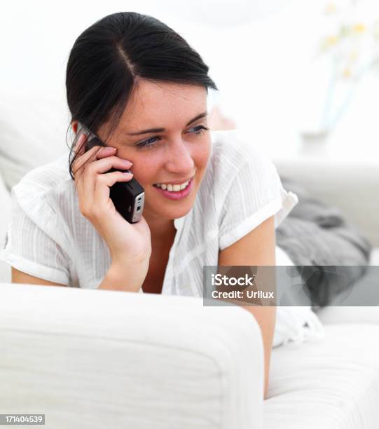 Young Lady Descansar En El Sofá Hablando Por Teléfono Foto de stock y más banco de imágenes de Acostado