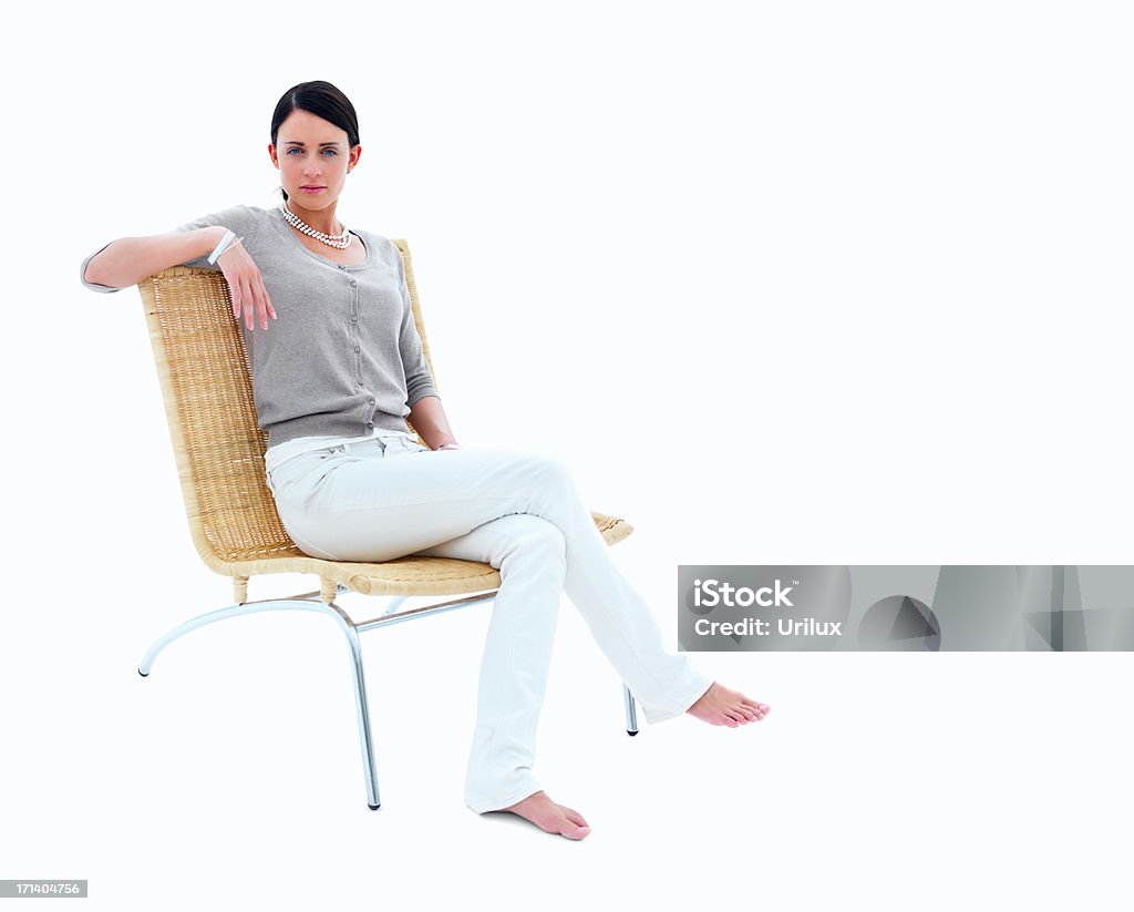 Young woman sitting on chair against isolated white background  Adult Stock Photo