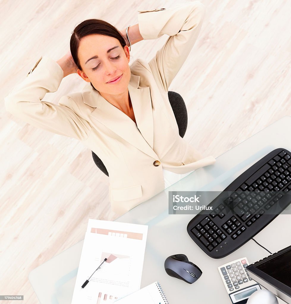 Sorridente bella donna d'affari rilassante alla scrivania del computer - Foto stock royalty-free di Adulto