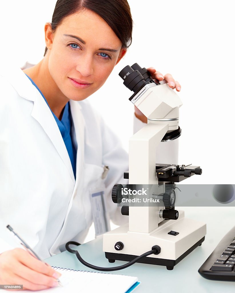 Weibliche Wissenschaftler mit Mikroskop und Schreiben Notizen auf Weiß - Lizenzfrei Arbeiten Stock-Foto