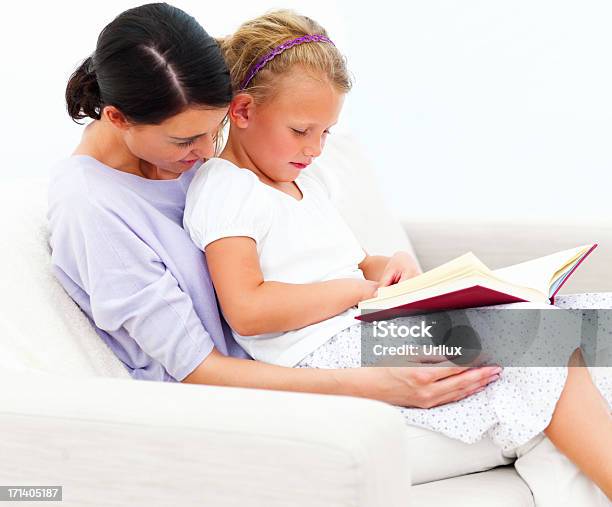 Foto de Mãe E Filha Sentada No Sofá Lendo Livro E e mais fotos de stock de Adulto - Adulto, Beleza, Criança