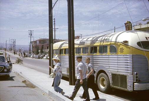 Tijuana (?), Mexico, 1965. Tourists visit the border town of Tijuana. Also: a bus, locals and buildings.