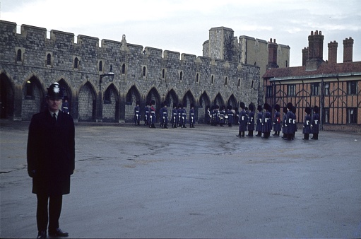 Windsor Castle, England, UK, 1976. Her Majesty's Grenadiers drill inside Windsor Castle. Also: A police officer (Bobby).